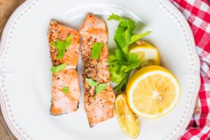 Gebackener Lachs mit Zitronen-Kräuter-Kruste auf weißem Teller